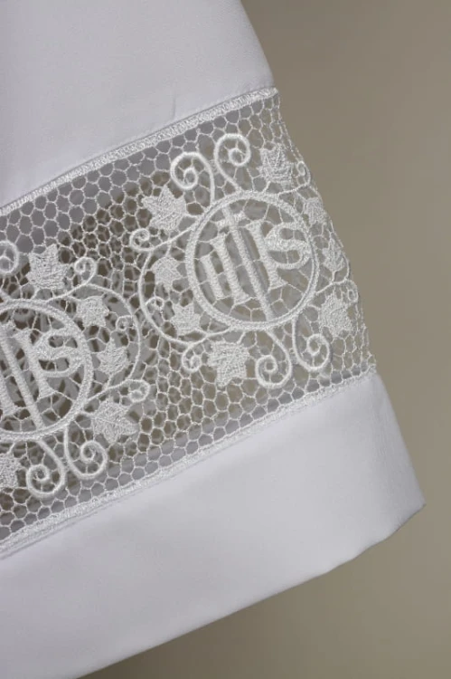 Alba kapłańska z ozdobną wstawką symbolem iHS.