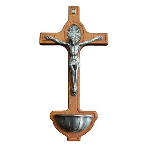 Drewniana kropielnica ścienna z krzyżem św. Benedykta, metalowym wizerunkiem Chrystusa Ukrzyżowanego i miseczką na wodę święconą, 21,5 × 11 cm.
