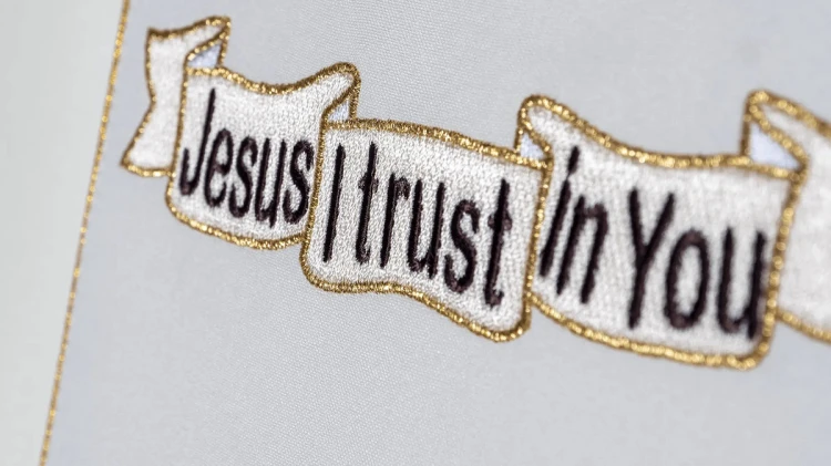 Zdjęcie hurtowni – detal haftu z angielskim napisem Jesus I trust in You