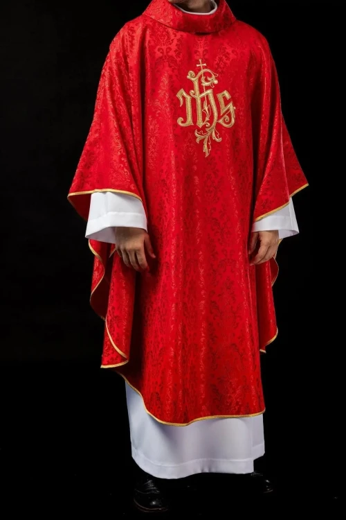 Czerwony ornat liturgiczny z haftowanym motywem IHS na ozdobnej tkaninie – pełny widok