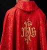 Czerwony ornat liturgiczny z haftowanym motywem IHS na ozdobnej tkaninie – wykończenie kołnierza