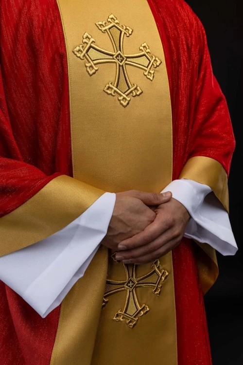 Czerwony ornat z haftowanym motywem krzyża i złotym pasem – detal symbolu
