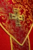 Czerwony ornat z krzyżem i tkaniną żakardową – zbliżenie haftu