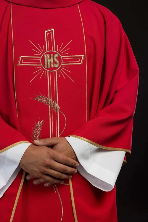 Czerwony ornat z szerokim, haftowanym złotym paskiem i krzyżem IHS – detal symbolu
