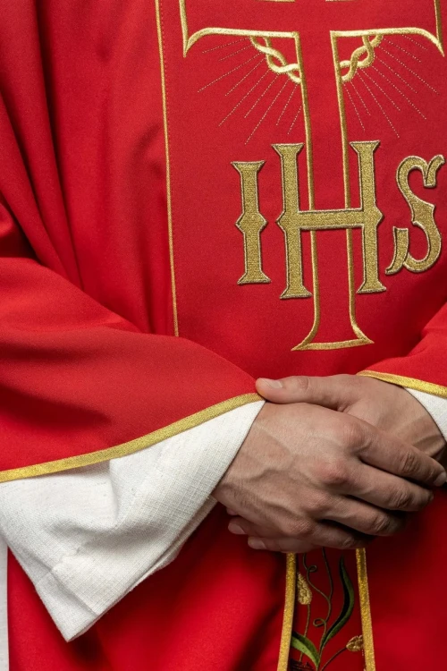 Czerwony ornat ze zdobionym złotym pasem z IHS i kłosami – detal symbolu