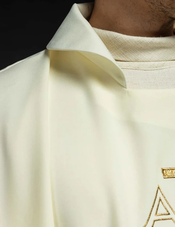 Ornat ecru z haftem Alfa i Omega i szerokim kołnierzem – detal symbolu