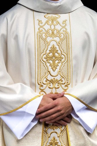 Ornat ecru z połyskującej tkaniny z bogatym złotym haftem na pasie