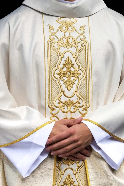 Ornat ecru z połyskującej tkaniny z bogatym złotym haftem na pasie