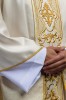 Ornat ecru z połyskującej tkaniny z bogatym złotym haftem na pasie – detal symbolu