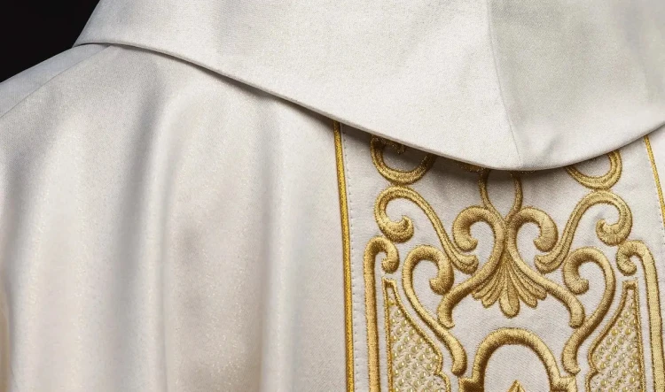 Ornat ecru z połyskującej tkaniny z bogatym złotym haftem na pasie – widok przodu