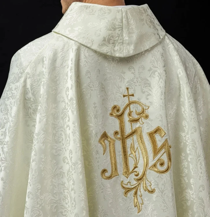 Ornat liturgiczny ecru z haftem IHS na ozdobnej tkaninie – detal symbolu