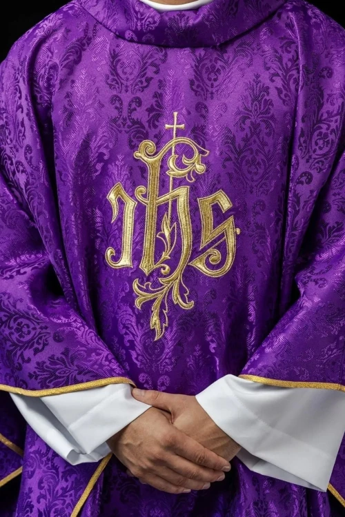 Fioletowy ornat liturgiczny z haftowanym motywem IHS na ozdobnej tkaninie