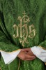 Zielony ornat liturgiczny z haftowanym motywem IHS na ozdobnej tkaninie – zbliżenie haftu