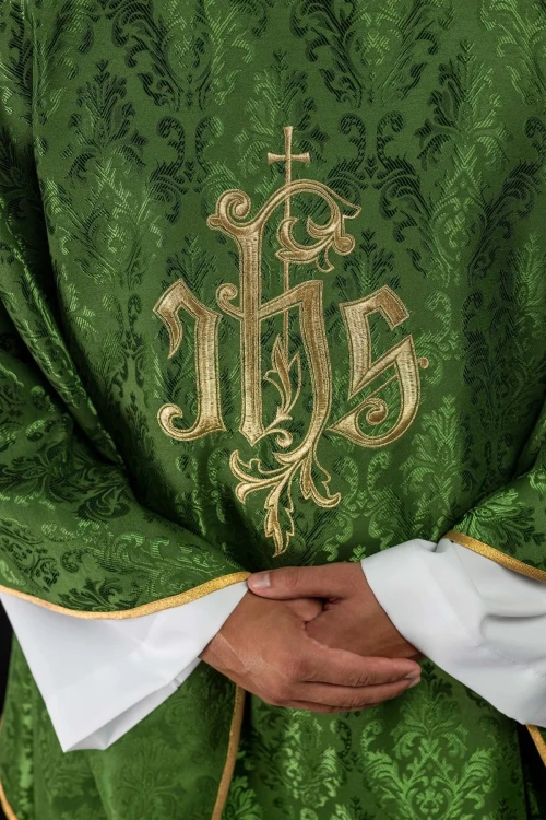 Zielony ornat liturgiczny z haftowanym motywem IHS na ozdobnej tkaninie – zbliżenie haftu