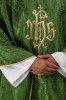 Zielony ornat liturgiczny z haftowanym motywem IHS na ozdobnej tkaninie – detal symbolu