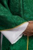 Zielony ornat z motywem IHS i bogato haftowanym kołnierzem na dekoracyjnej tkaninie – detal symbolu