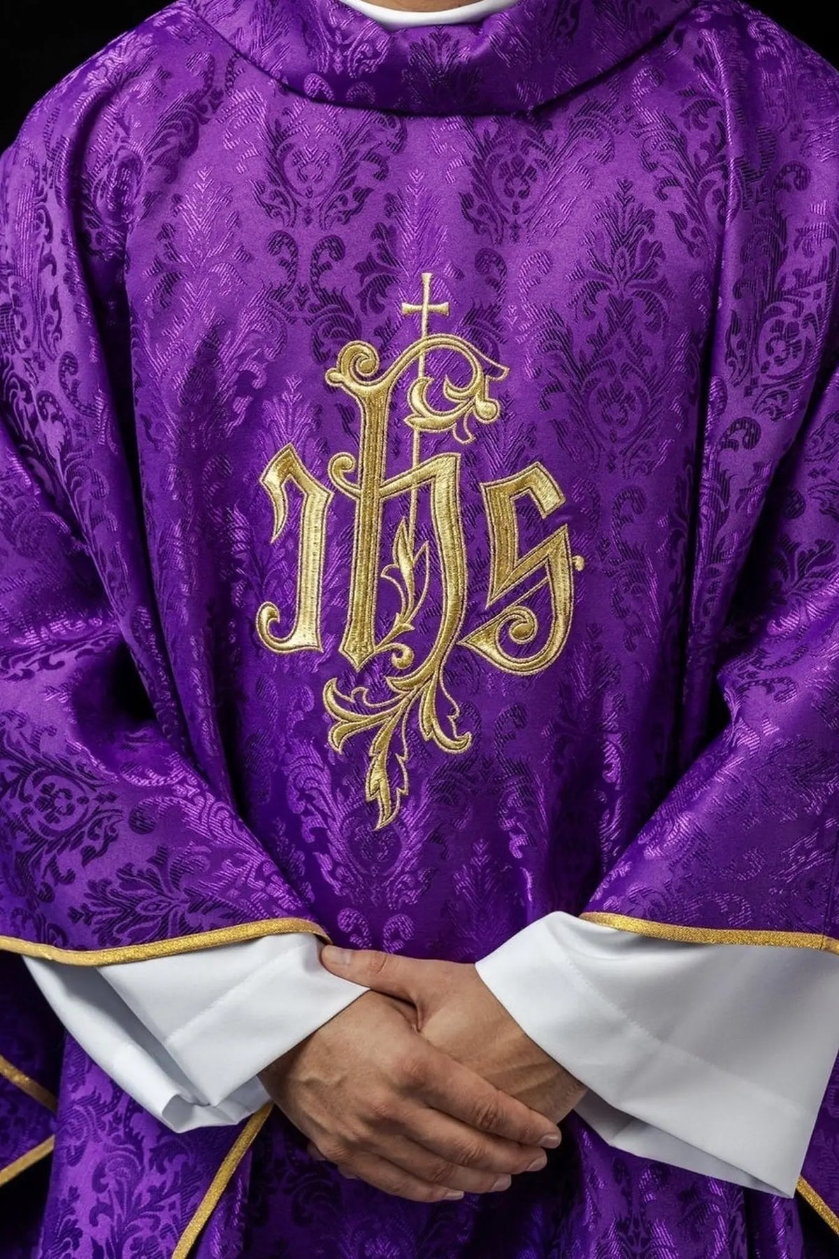Fioletowy ornat liturgiczny z haftowanym motywem IHS na ozdobnej tkaninie